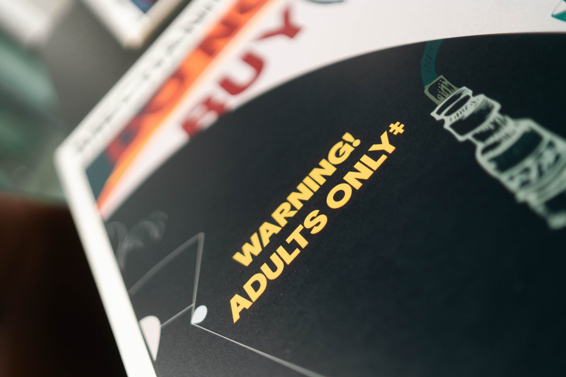 Close-up of the yellow WARNING ADULTS ONLY text on black